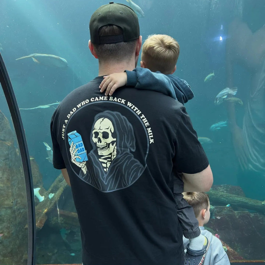 Wearing Milk Dad Shirt and Holding Kids at the Aquarium